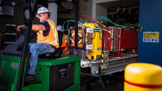 Workers remove the final girder of the original APS. The new ring will be made up of 200 modules, each with precisely aligned electromagnets and complex vacuum and electrical systems. (Image by Argonne National Laboratory/J.J Starr.)